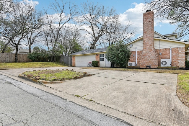 view of front facade with driveway, brick siding, fence, and a chimney