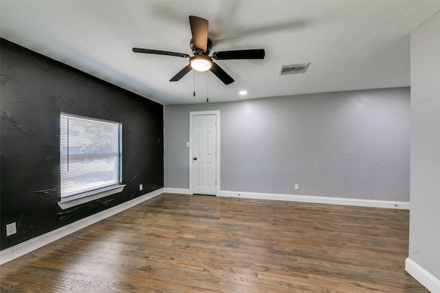 unfurnished room featuring visible vents, ceiling fan, baseboards, and wood finished floors