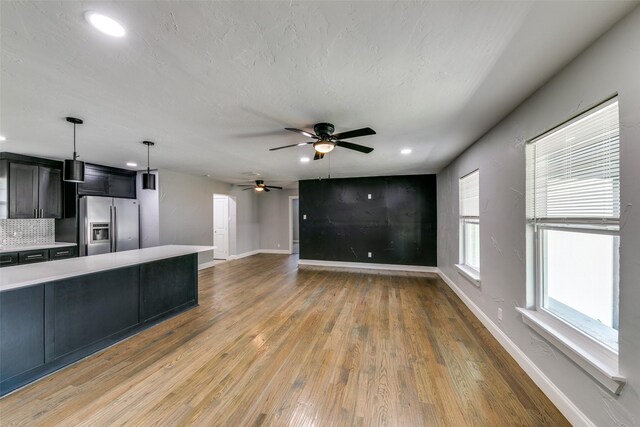kitchen featuring light wood-type flooring, baseboards, light countertops, and stainless steel fridge with ice dispenser