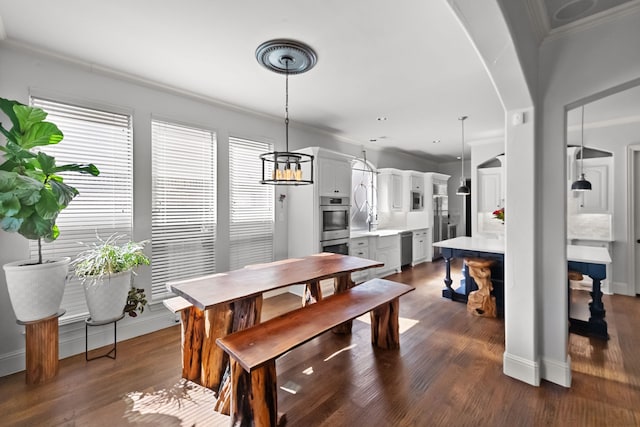 dining area featuring baseboards, ornamental molding, arched walkways, and dark wood-style flooring