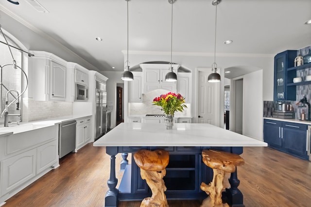 kitchen featuring blue cabinetry, open shelves, white cabinetry, wood finished floors, and built in appliances