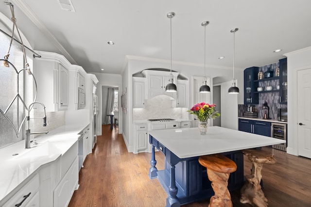 kitchen featuring wine cooler, wood finished floors, a sink, white cabinets, and open shelves