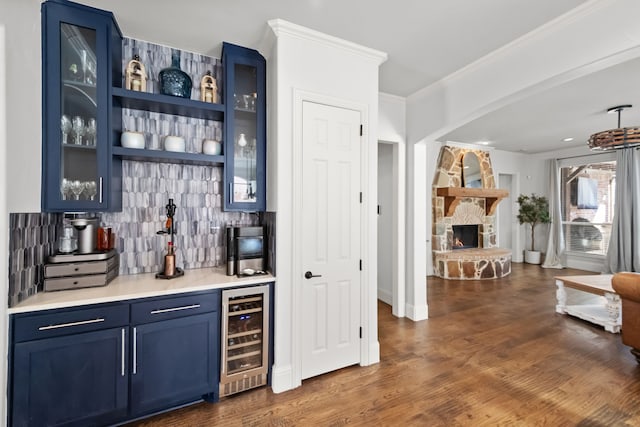 bar featuring a dry bar, wine cooler, ornamental molding, dark wood-style flooring, and backsplash