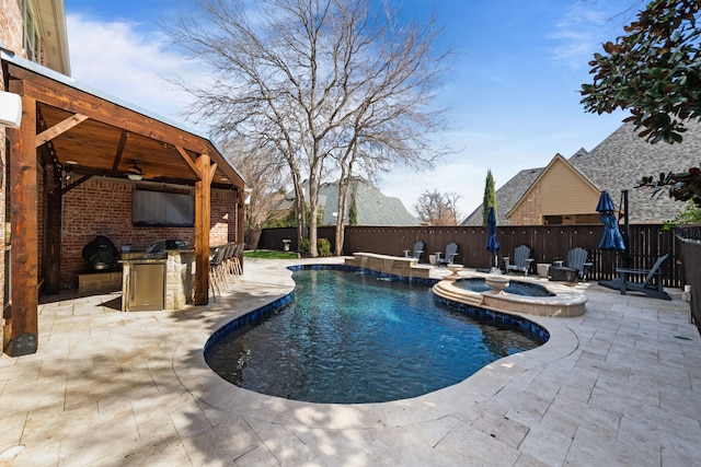 view of pool featuring a patio area, a fenced backyard, and exterior kitchen