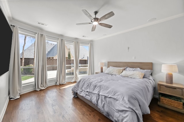 bedroom featuring ceiling fan, wood finished floors, visible vents, and crown molding