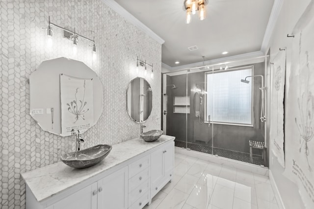 full bathroom featuring double vanity, a stall shower, ornamental molding, and a sink