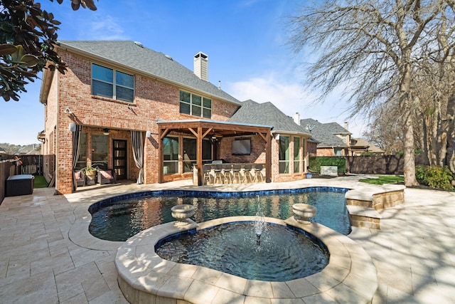 view of pool with outdoor dry bar, a patio, a fenced backyard, and a pool with connected hot tub