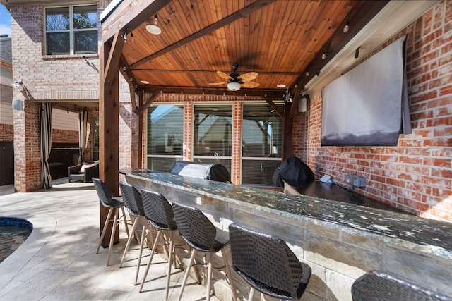 view of patio featuring a grill, outdoor wet bar, a ceiling fan, and area for grilling