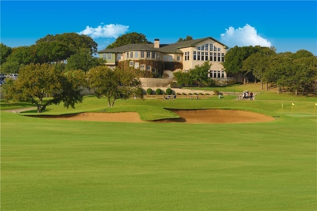 view of home's community with golf course view and a yard