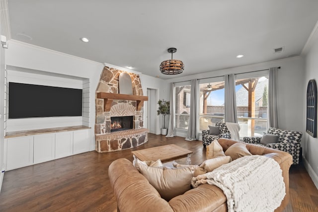 living room with ornamental molding, dark wood-style flooring, a fireplace, and visible vents