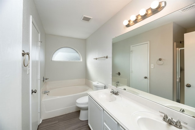 bathroom with a bath, visible vents, a sink, and wood finished floors