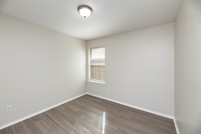 unfurnished room featuring wood finished floors and baseboards