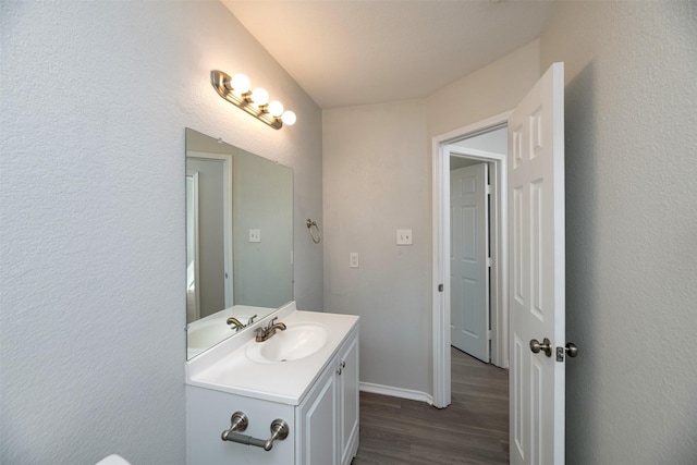 bathroom featuring wood finished floors, vanity, and baseboards