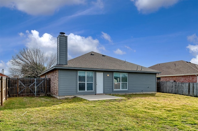 rear view of property featuring a patio, a lawn, a chimney, and a fenced backyard