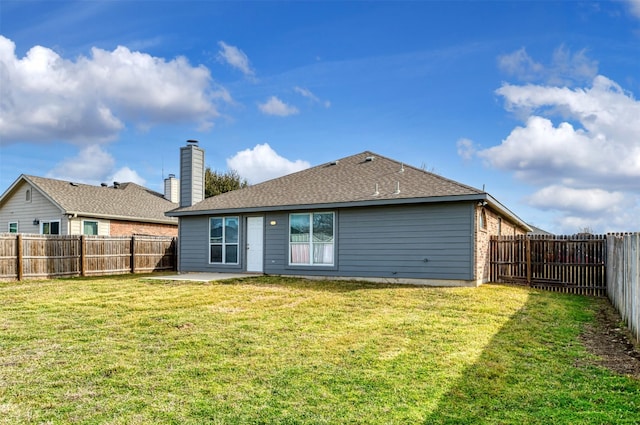 rear view of house with a patio area, a fenced backyard, a lawn, and roof with shingles