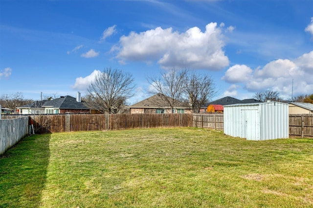 view of yard with a fenced backyard, a storage unit, and an outdoor structure