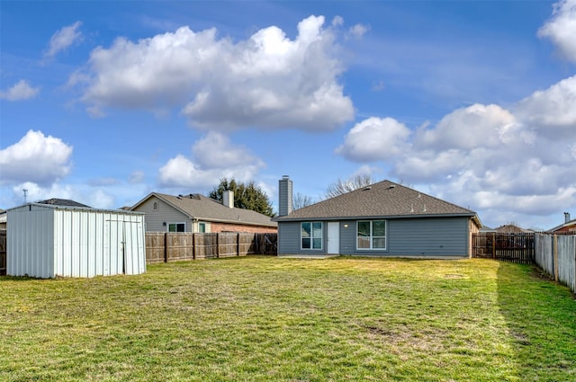 exterior space with a storage unit, a lawn, an outdoor structure, and a fenced backyard