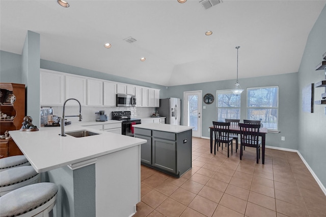 kitchen featuring visible vents, lofted ceiling, appliances with stainless steel finishes, a sink, and backsplash