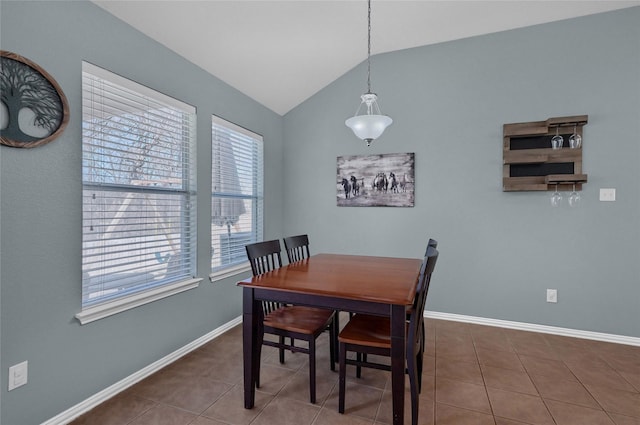 dining room featuring lofted ceiling, baseboards, and tile patterned floors