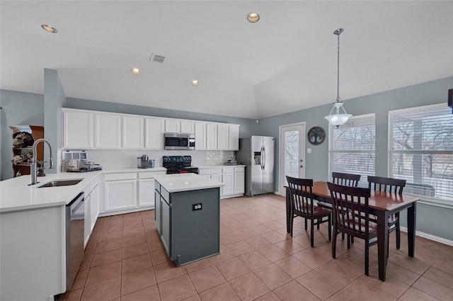 kitchen with stainless steel appliances, lofted ceiling, visible vents, hanging light fixtures, and a sink