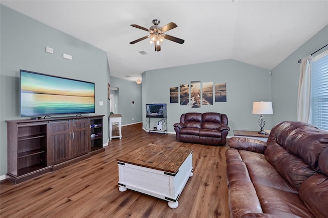 living area with lofted ceiling, wood finished floors, a ceiling fan, visible vents, and baseboards