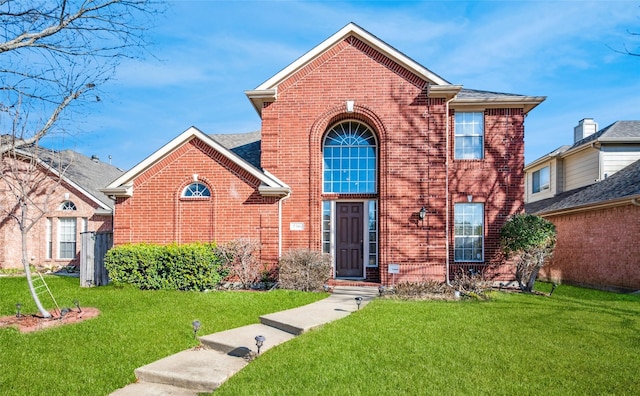 traditional-style home featuring brick siding and a front lawn