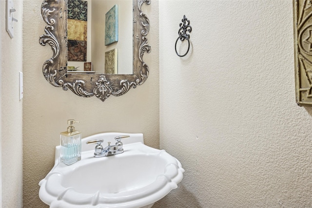 bathroom with a textured wall and a sink