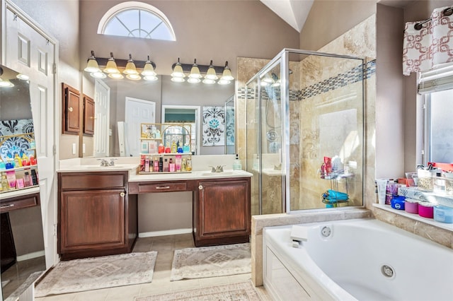 full bath with double vanity, a tub with jets, a sink, and a shower stall