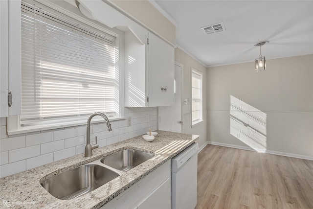 kitchen with visible vents, decorative backsplash, dishwasher, light wood-style flooring, and a sink