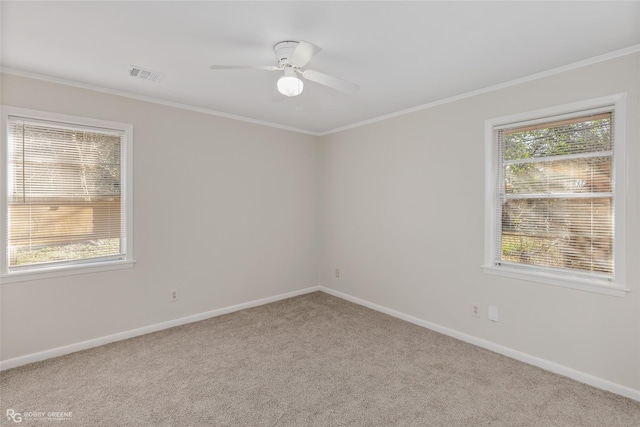 spare room featuring baseboards, carpet, visible vents, and crown molding