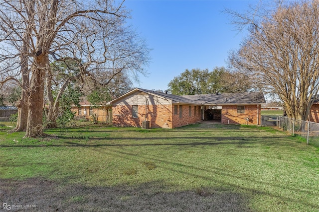 view of front of home with brick siding, a front yard, and fence