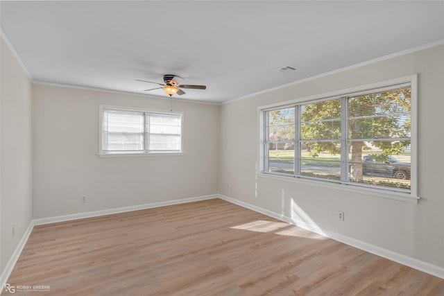 empty room with ornamental molding, visible vents, and light wood-style flooring