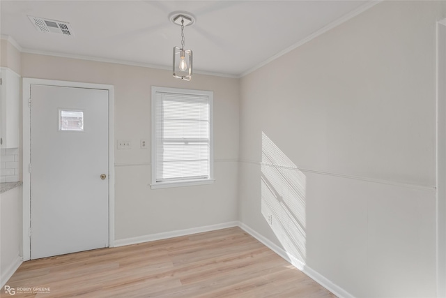 foyer with baseboards, light wood finished floors, visible vents, and crown molding