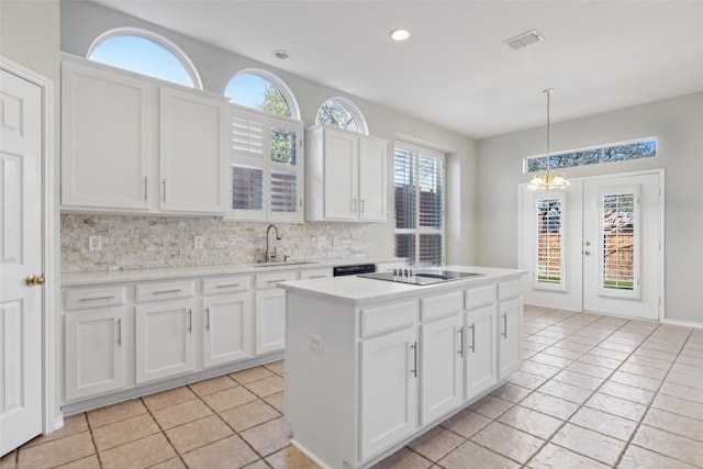 kitchen with black electric stovetop, a sink, visible vents, white cabinetry, and backsplash