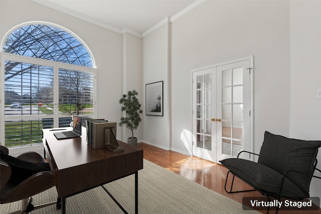 home office featuring french doors, a high ceiling, ornamental molding, wood finished floors, and baseboards