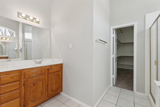 bathroom with a stall shower, tile patterned flooring, and a walk in closet