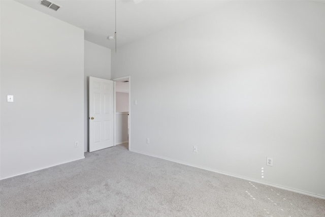 empty room featuring baseboards, visible vents, and light colored carpet