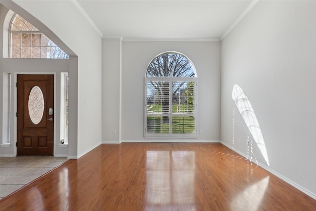 entrance foyer featuring ornamental molding, baseboards, and wood finished floors