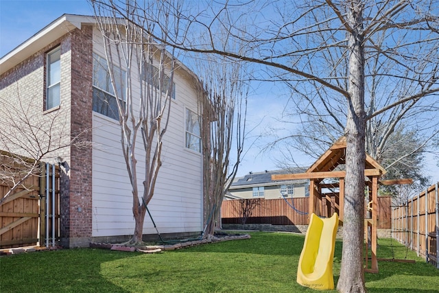 view of yard featuring a playground and a fenced backyard