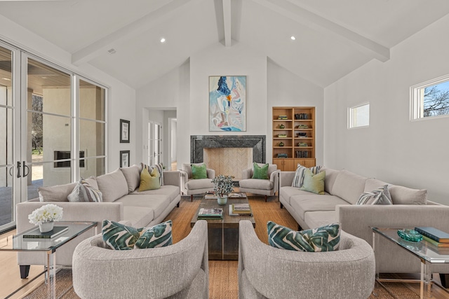 living area featuring beam ceiling, recessed lighting, a high end fireplace, wood finished floors, and high vaulted ceiling