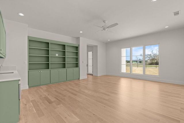 unfurnished living room featuring recessed lighting, a sink, a ceiling fan, visible vents, and light wood-style floors