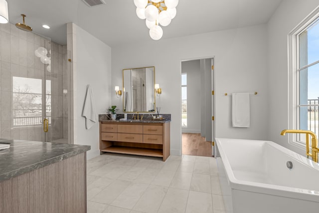 bathroom featuring tiled shower, a soaking tub, vanity, and a notable chandelier