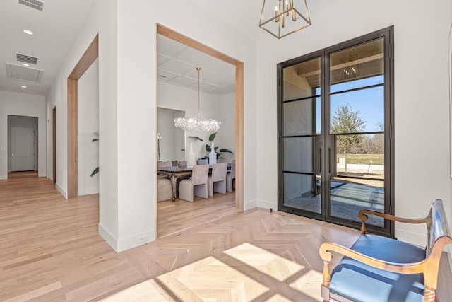 interior space featuring a chandelier, visible vents, and baseboards