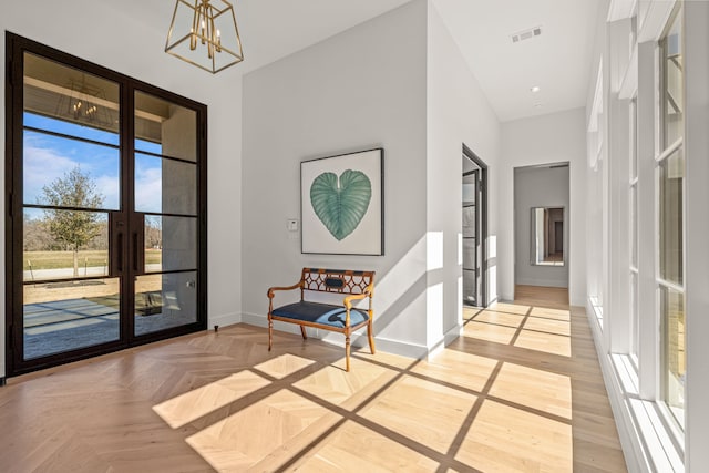 interior space featuring a chandelier, french doors, visible vents, and baseboards