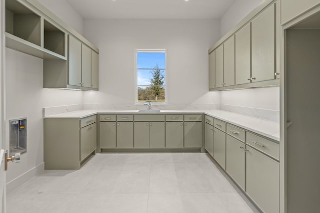 kitchen featuring light stone countertops, a sink, and light tile patterned floors