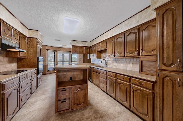 268 Roland Rd, Whitesboro, TX 76273 - kitchen featuring decorative backsplash, a kitchen island, light countertops, black appliances, and a sink
