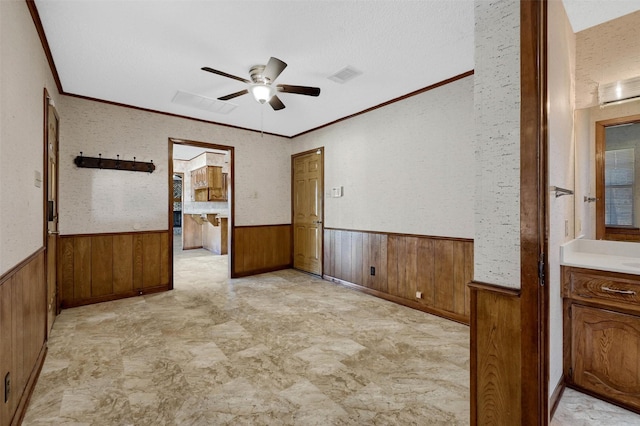 268 Roland Rd, Whitesboro, TX 76273 - unfurnished room featuring a ceiling fan, visible vents, a wainscoted wall, and wooden walls