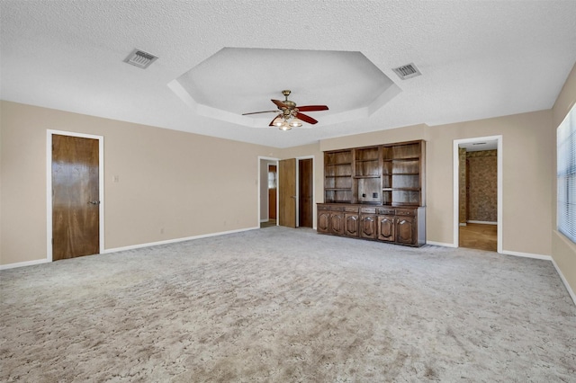 268 Roland Rd, Whitesboro, TX 76273 - unfurnished living room featuring light carpet, visible vents, and a raised ceiling