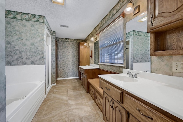 268 Roland Rd, Whitesboro, TX 76273 - bathroom featuring a textured ceiling, visible vents, baseboards, a bath, and wallpapered walls