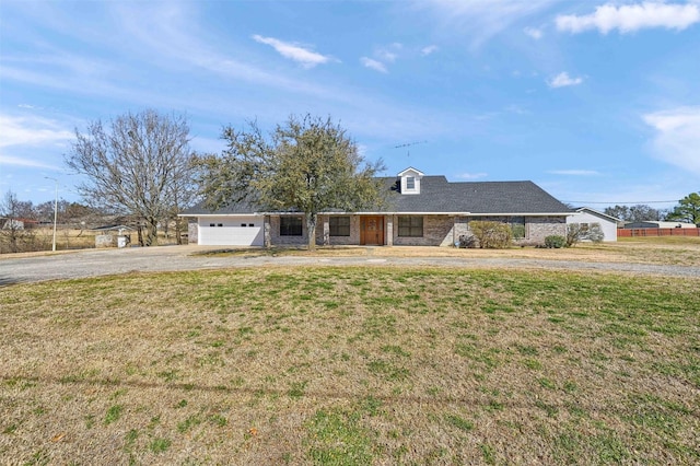 view of front of property with a garage, brick siding, driveway, and a front lawn